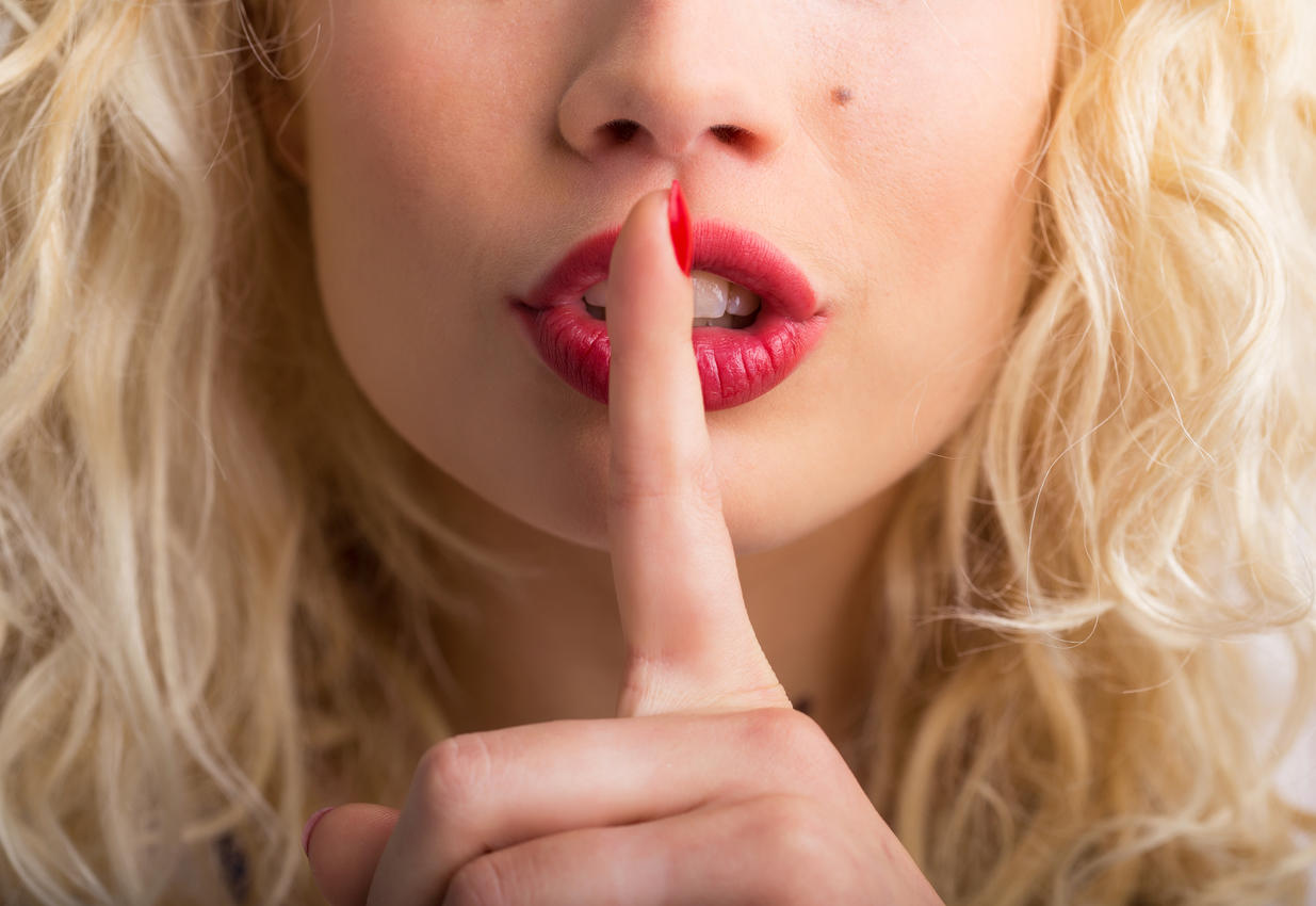 Woman holding her finger pressed against her lips