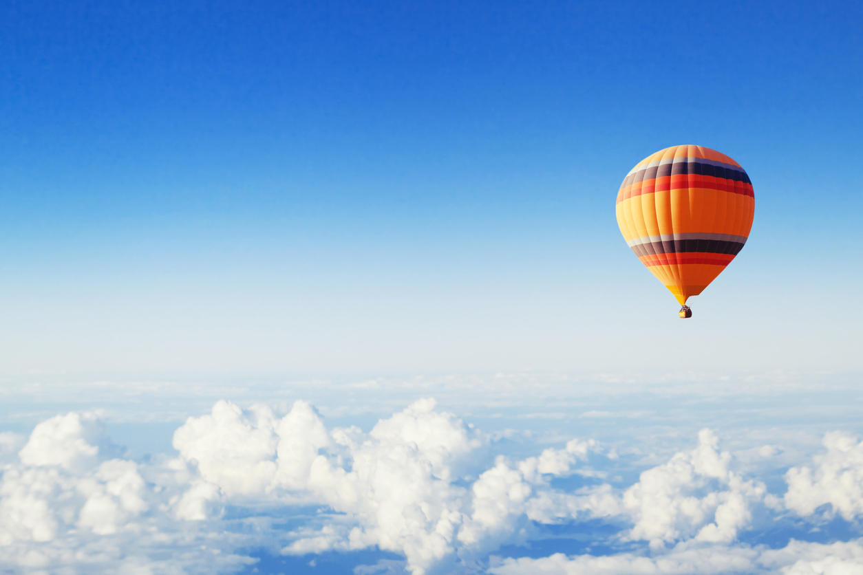 inspiration or travel background, hot air balloon over the clouds