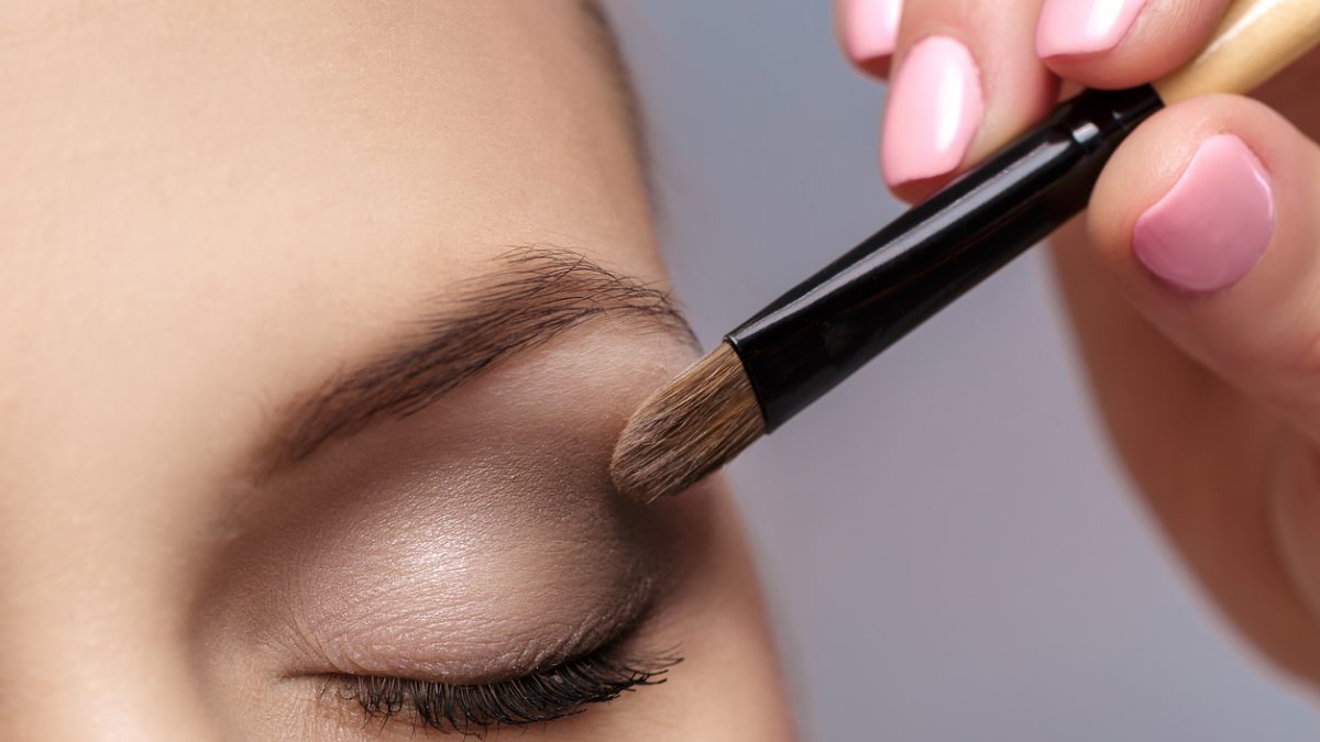 makeup artist apply makeup brush for eyes. makeup for young girl. brown eye shadow. close up