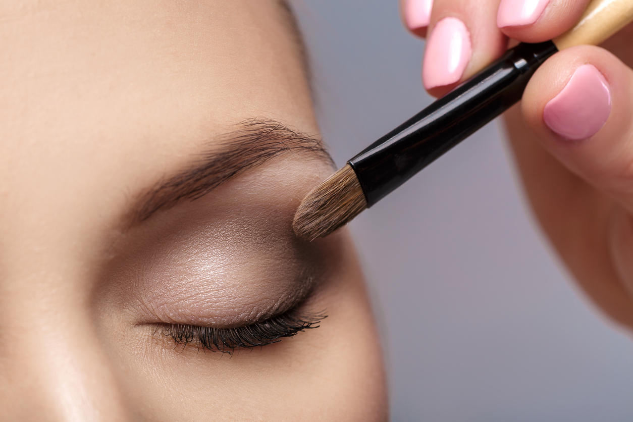 makeup artist apply makeup brush for eyes. makeup for young girl. brown eye shadow. close up