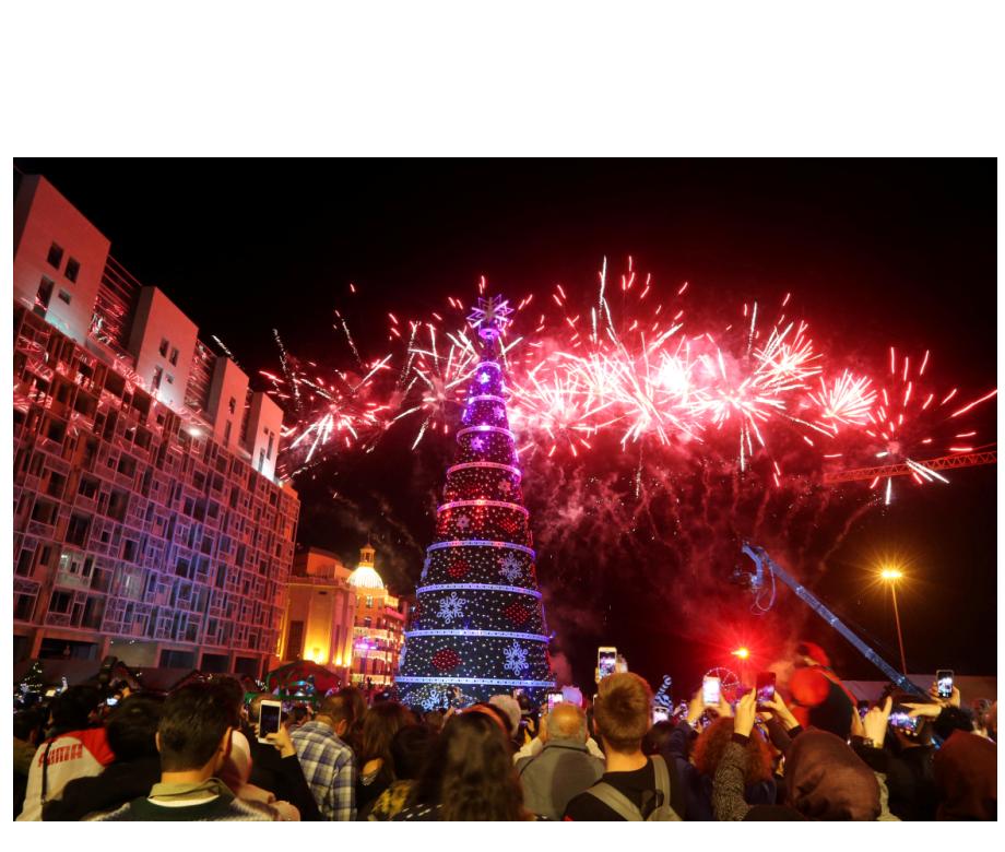 People gather as fireworks explode over an illuminated Christmas tree in Beirut, Lebanon December 3, 2018. REUTERS Mohamed Azakir