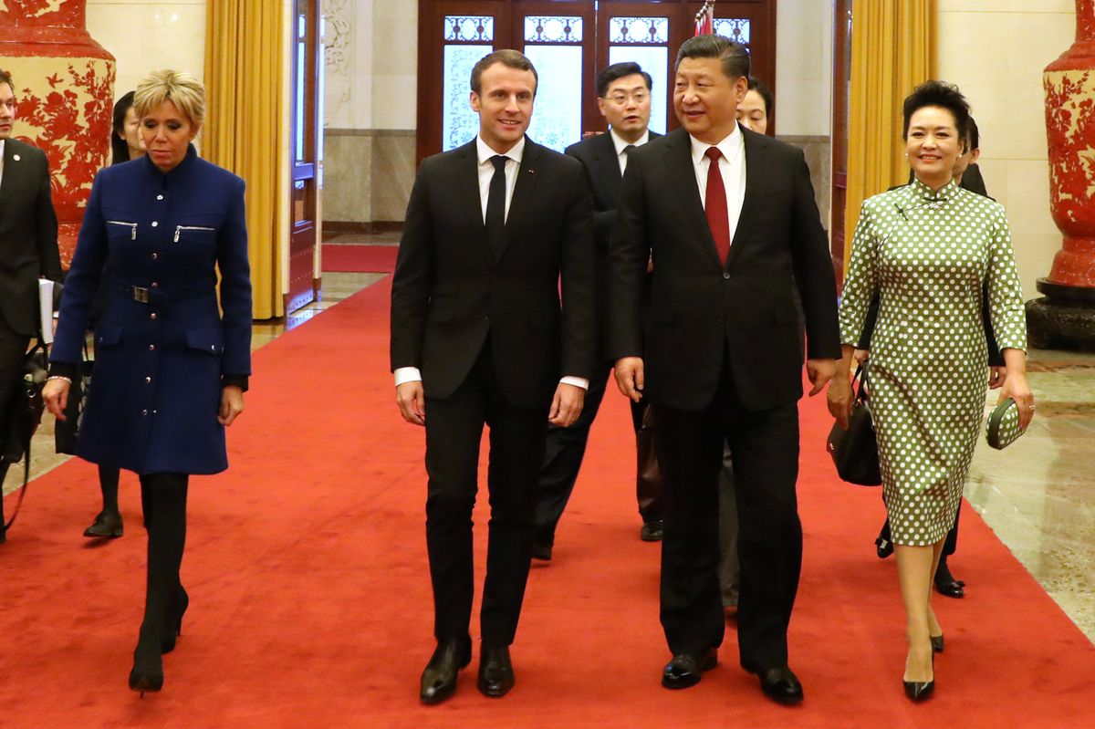 French President Emmanuel Macron and his wife Brigitte Macron walk with Chinese President Xi Jinping and Xi’s wife Peng Liyuan during their meeting at the Great Hall of the People in Beijing