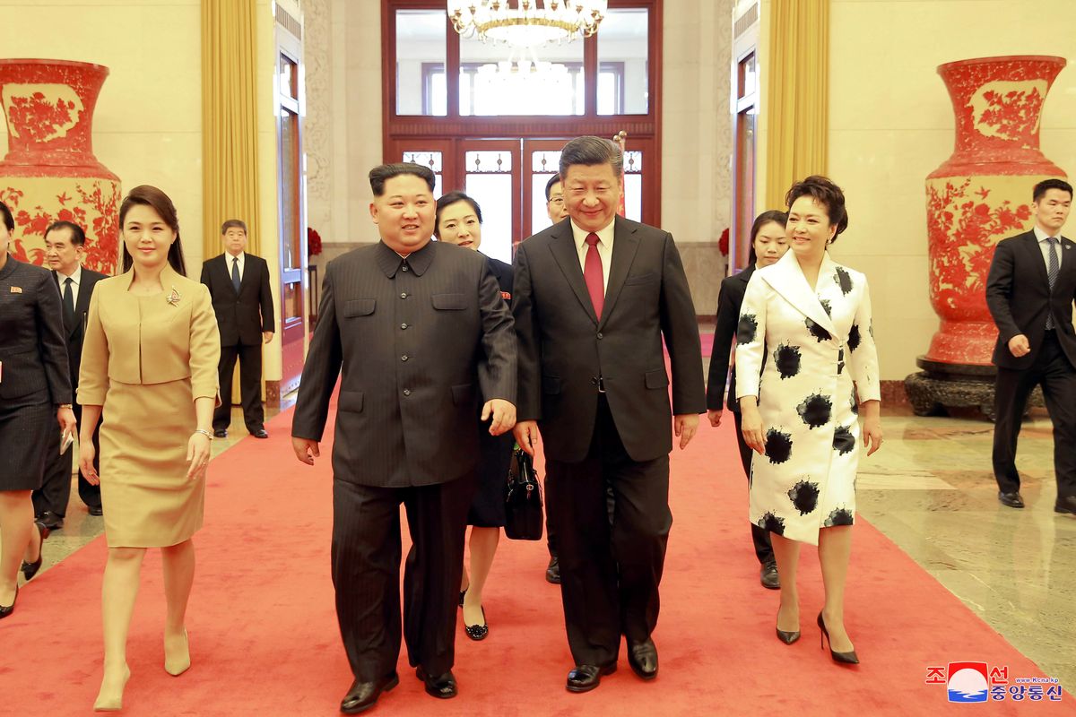 North Korean leader Kim Jong Un and wife Ri Sol Ju, and Chinese President Xi Jinping and wife Peng walk together