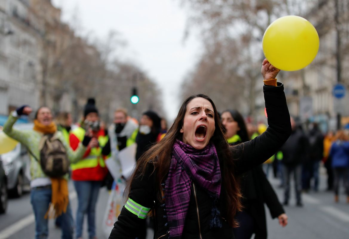 A protester holds a balloon as she takes part in a demonstration by the “Women’s yellow vests” movement in Paris