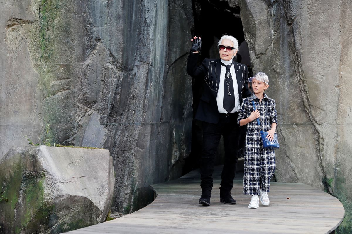 German designer Karl Lagerfeld appears with model Hudson Kroenig at the end of his Spring/Summer 2018 women’s ready-to-wear collection show for fashion house Chanel at the Grand Palais during Paris Fashion Week