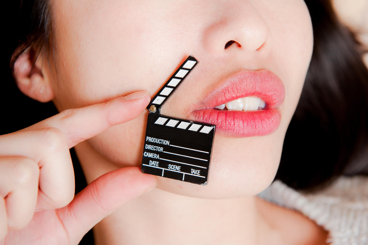 Face detail of sensual woman lips with little clapper board