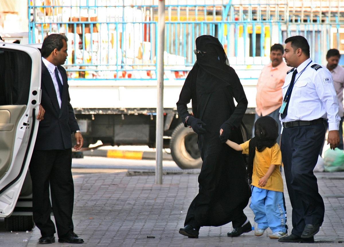 Michael Jackson, wearing an abaya, a traditional Arab women’s veil, holds the hand of a child as he ..