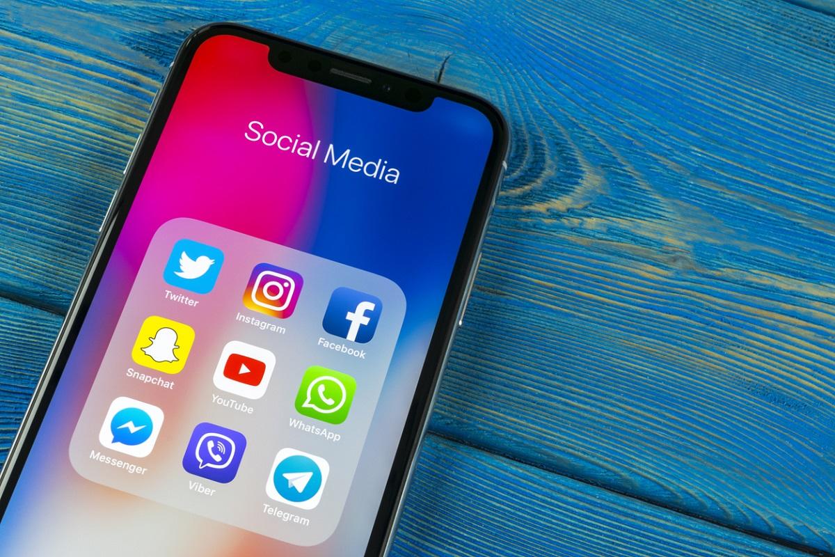 Apple iPhone X on office desk with icons of social media facebook, instagram, twitter, snapchat application on screen. Social network. Starting social media app.
