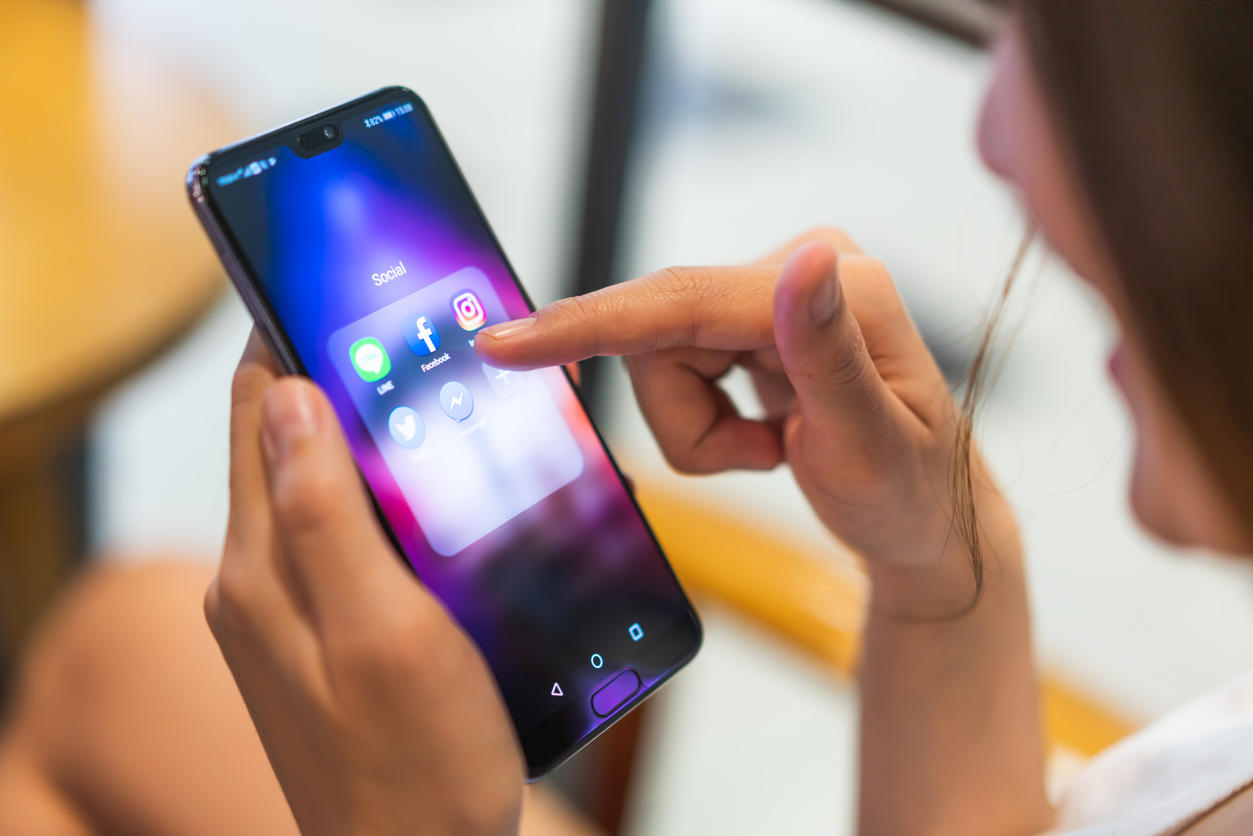 Asian woman using social media application on Huawei P20 pro smartphone, pointing at facebook app. Illustrative Editorial content.