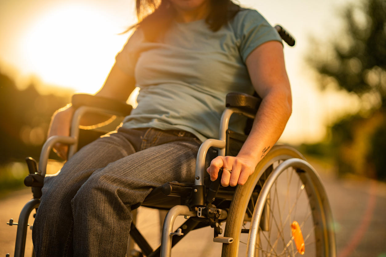 Unrecognizable women on a wheelchair at sunset