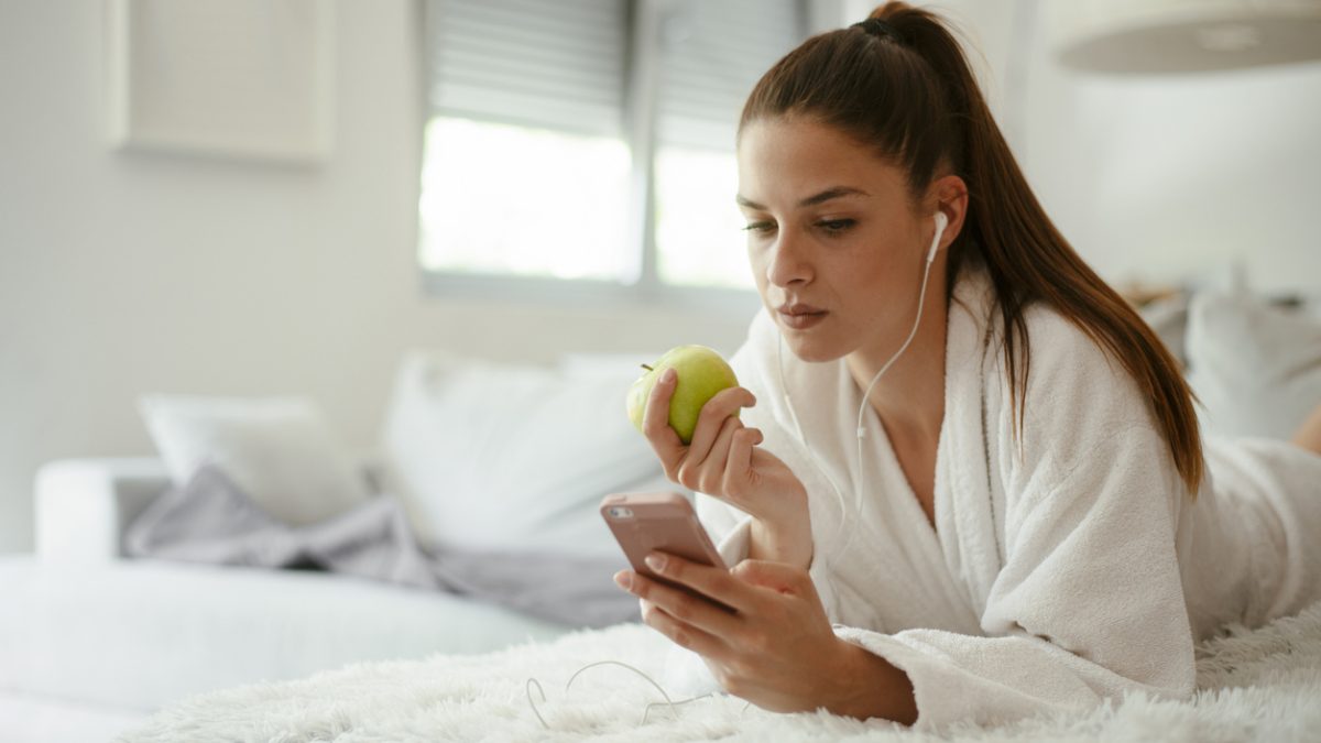 Young bautiful woman texting surfing the net on the sofa at home. stock photo