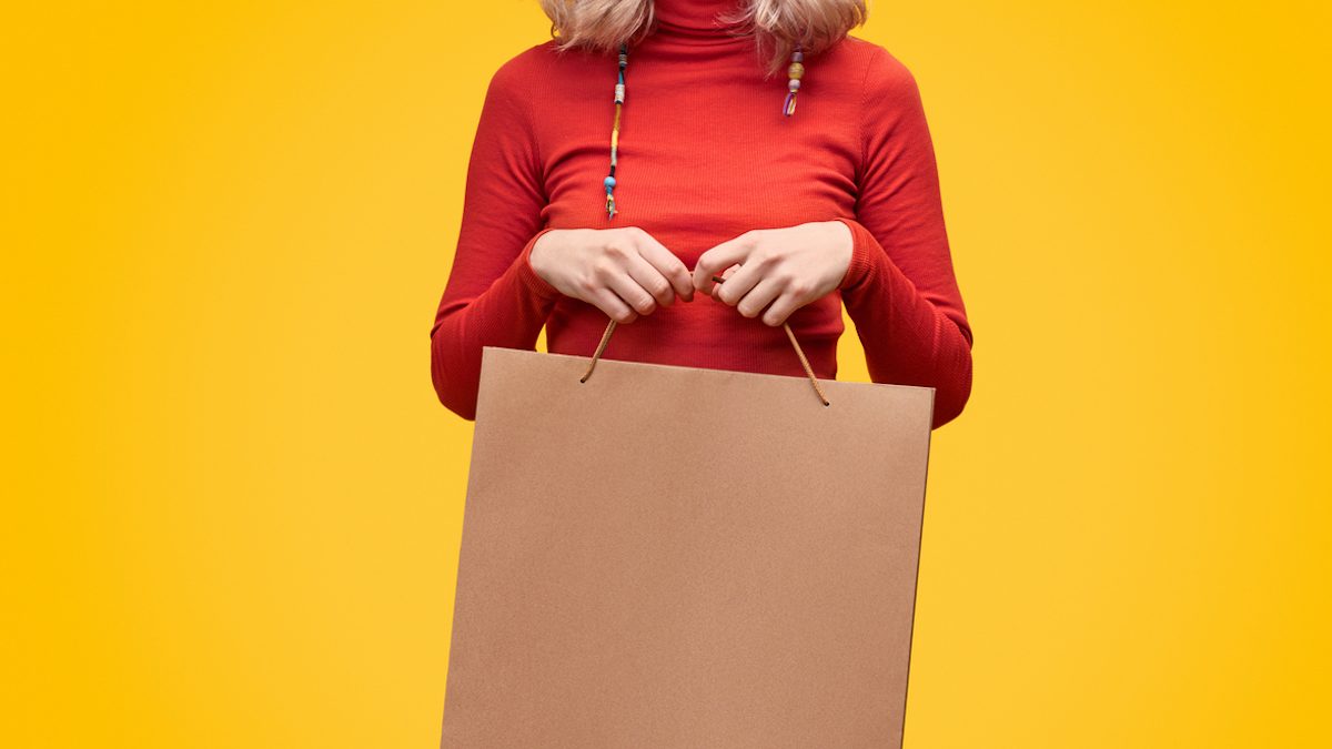 Crop woman with blank paper bag