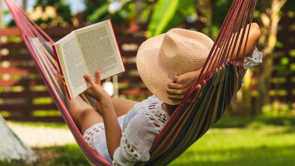 Attractive sexy woman reading book in hammock.
