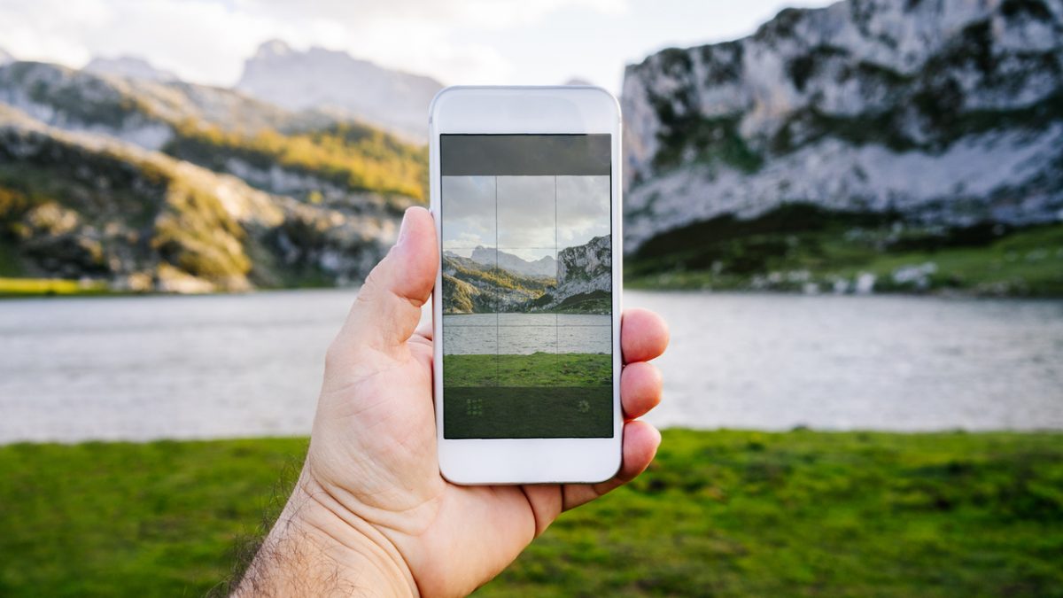 mobile phone making a photo of a mountain landscape