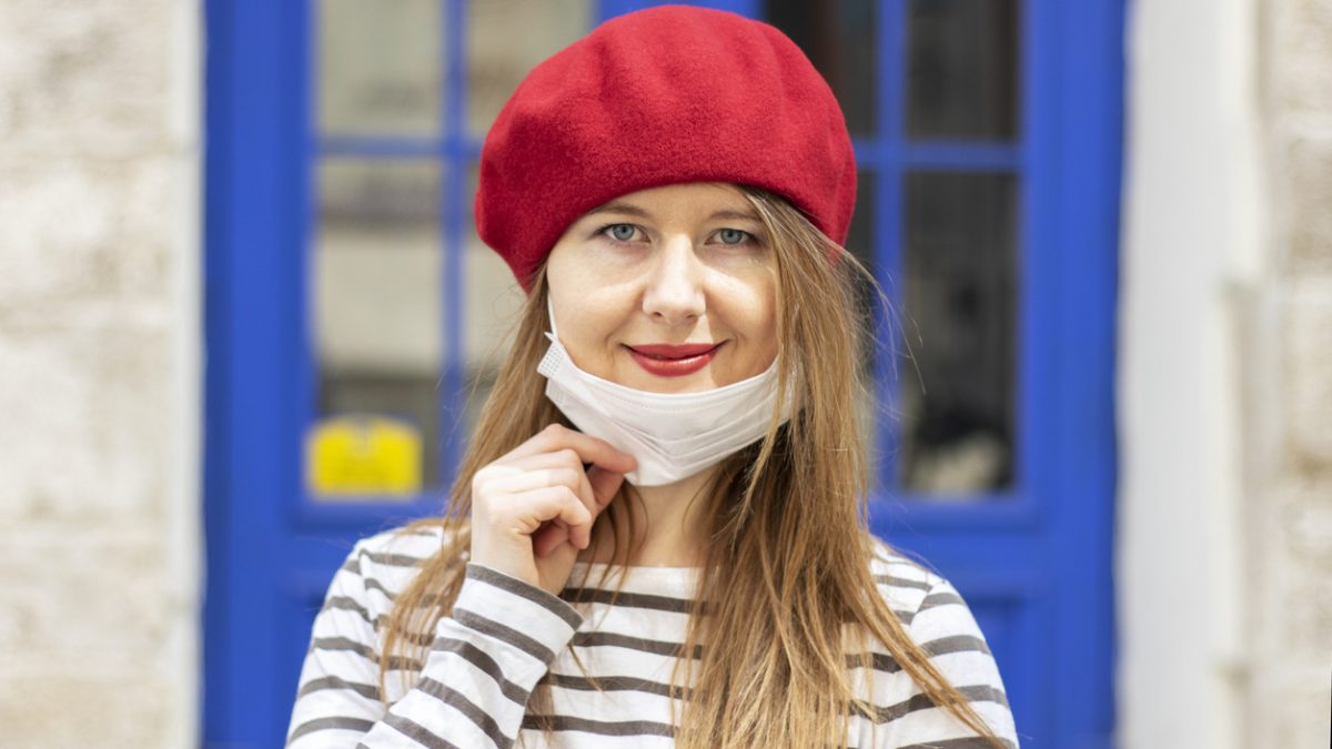 Portrait of a woman wearing surgical mask on chin. Masking policy concept.