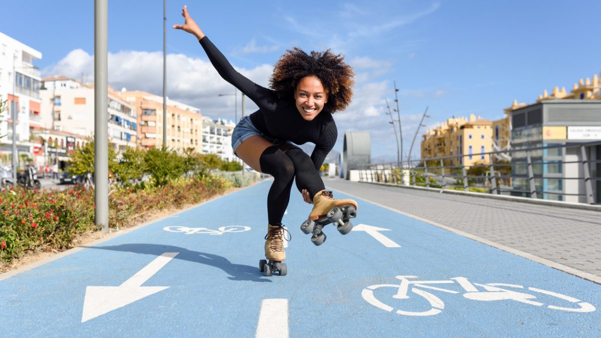 Black woman on roller skates riding on bike line